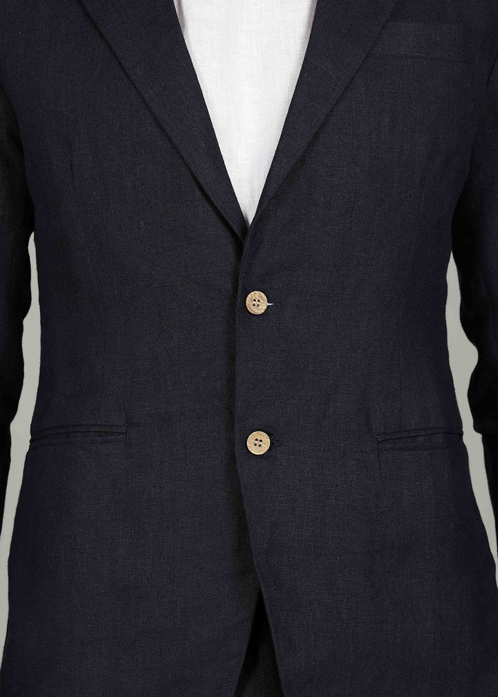 Man wearing a 100% pure linen regal blue jacket in 25 LEA over a white shirt on a gray background