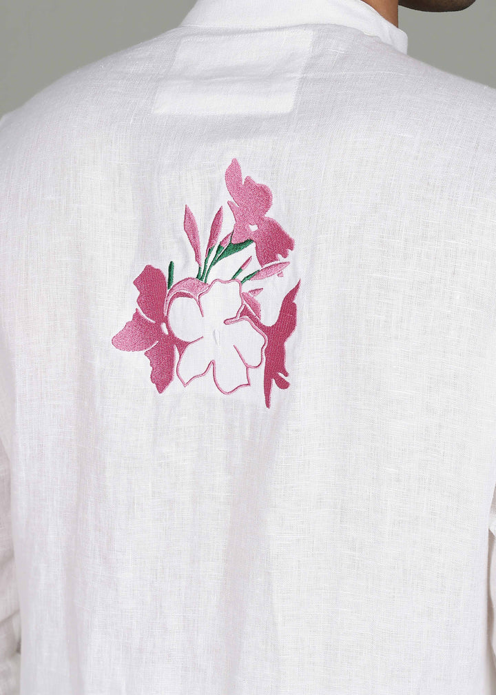 Man wearing a 100% pure linen white long kurta with pink floral design on the back in 44 LEA against a gray background