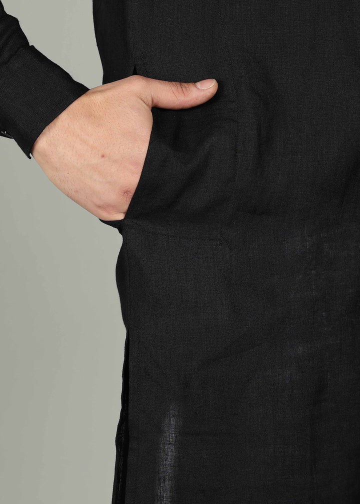 Man wearing a 100% pure linen black long kurta in 60 LEA with red piping detail with a gray background