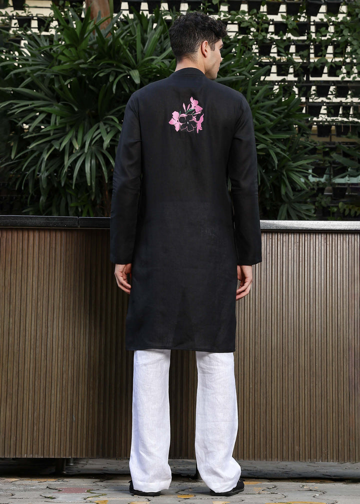 Man wearing a 100% pure linen black long kurta with pink floral design on the back in 60 LEA