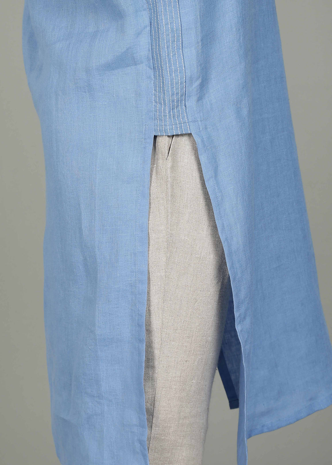 Man wearing a 100% pure linen olympic blue long kurta in 60 LEA with white detailing against a gray background