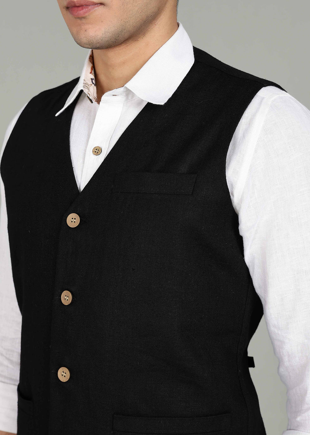 Man wearing a 100% pure linen black waistcoat in 25 LEA over a white shirt against a gray background