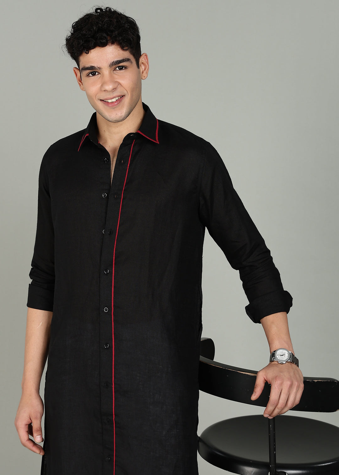 Man wearing a 100% pure linen black long kurta in 60 LEA with red piping detail with a gray background