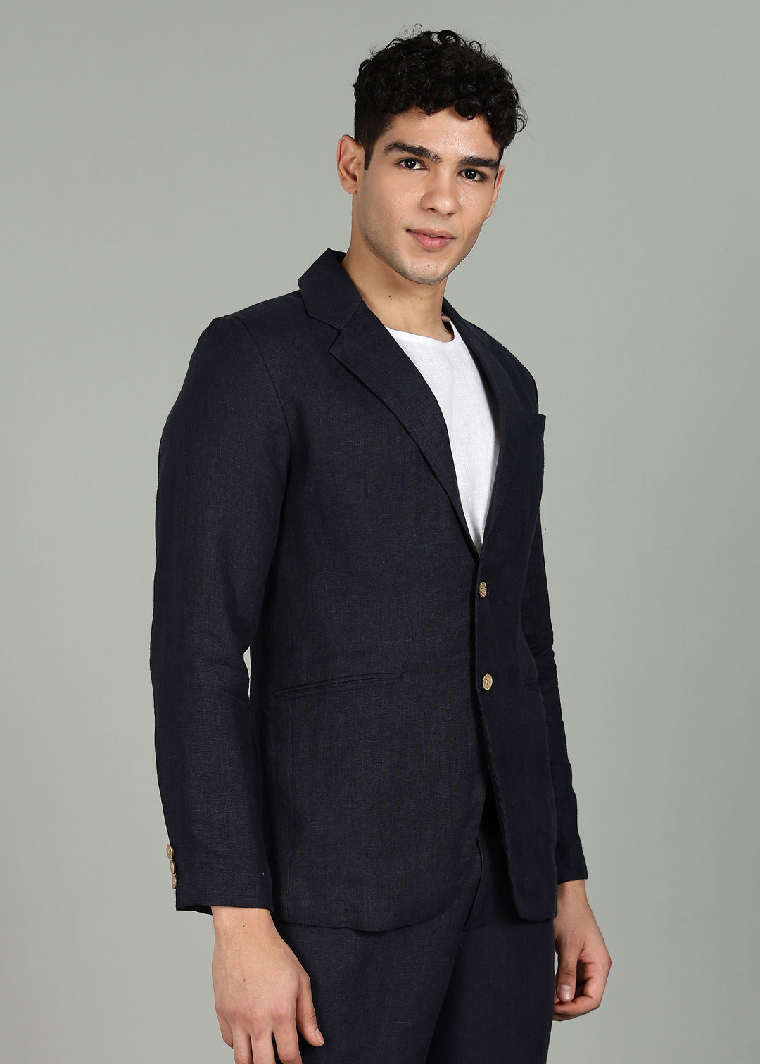 Man wearing a 100% pure linen regal blue jacket in 25 LEA over a white shirt on a gray background