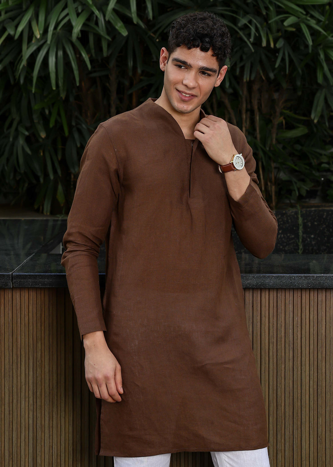 Man wearing a 100% pure linen Coffee Brown Kurta, in a green background outdoor.
