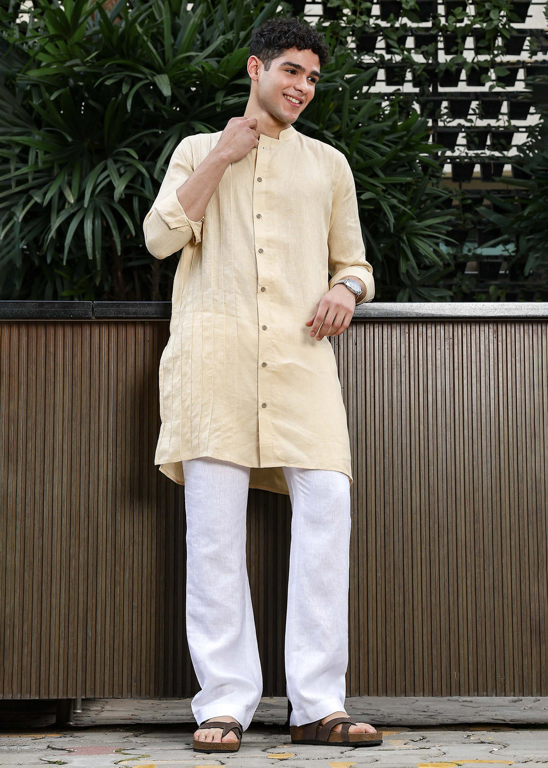 Man wearing a 100% pure light tea yellow Kurta, in a Green outdoor Background.
