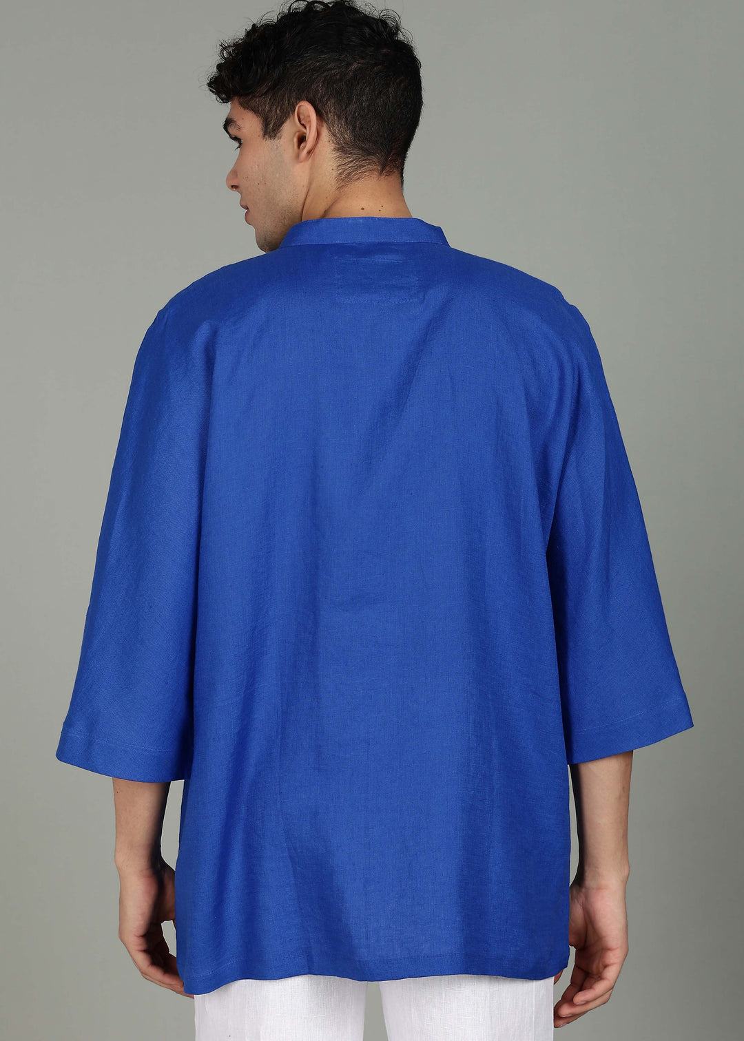 Man wearing a 100% pure linen egyptian blue short kurta in 60 LEA with a gray background