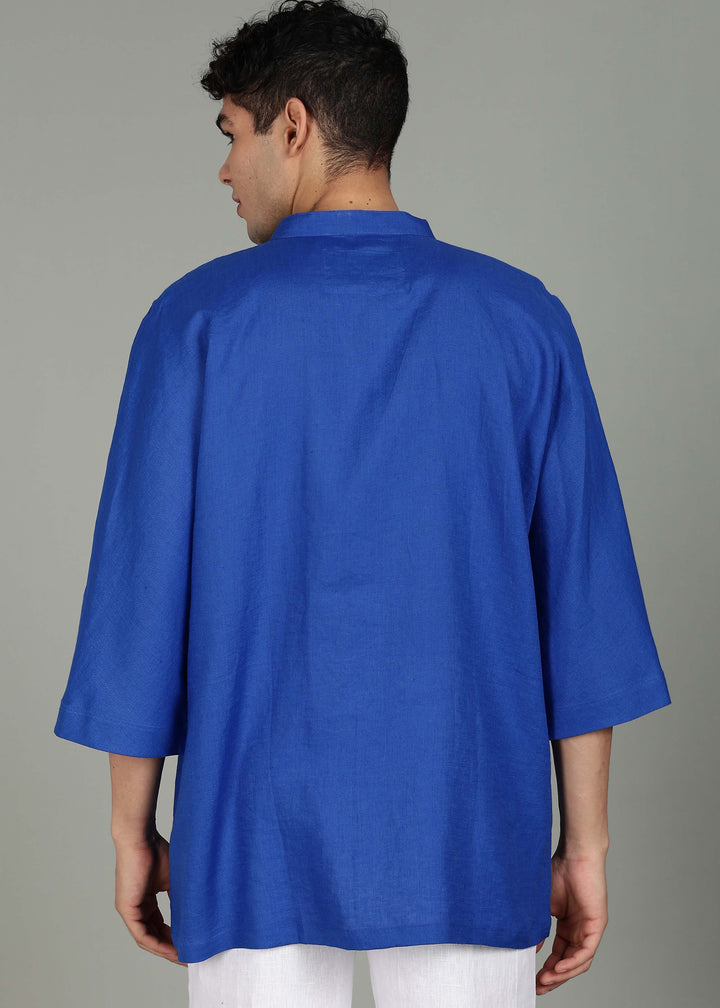Man wearing a 100% pure linen egyptian blue short kurta in 60 LEA with a gray background