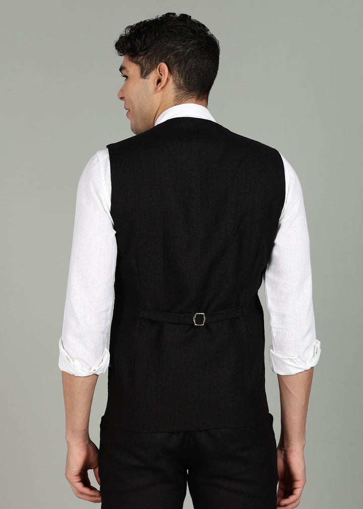 Man wearing a 100% pure linen black waistcoat in 25 LEA over a white shirt against a gray background