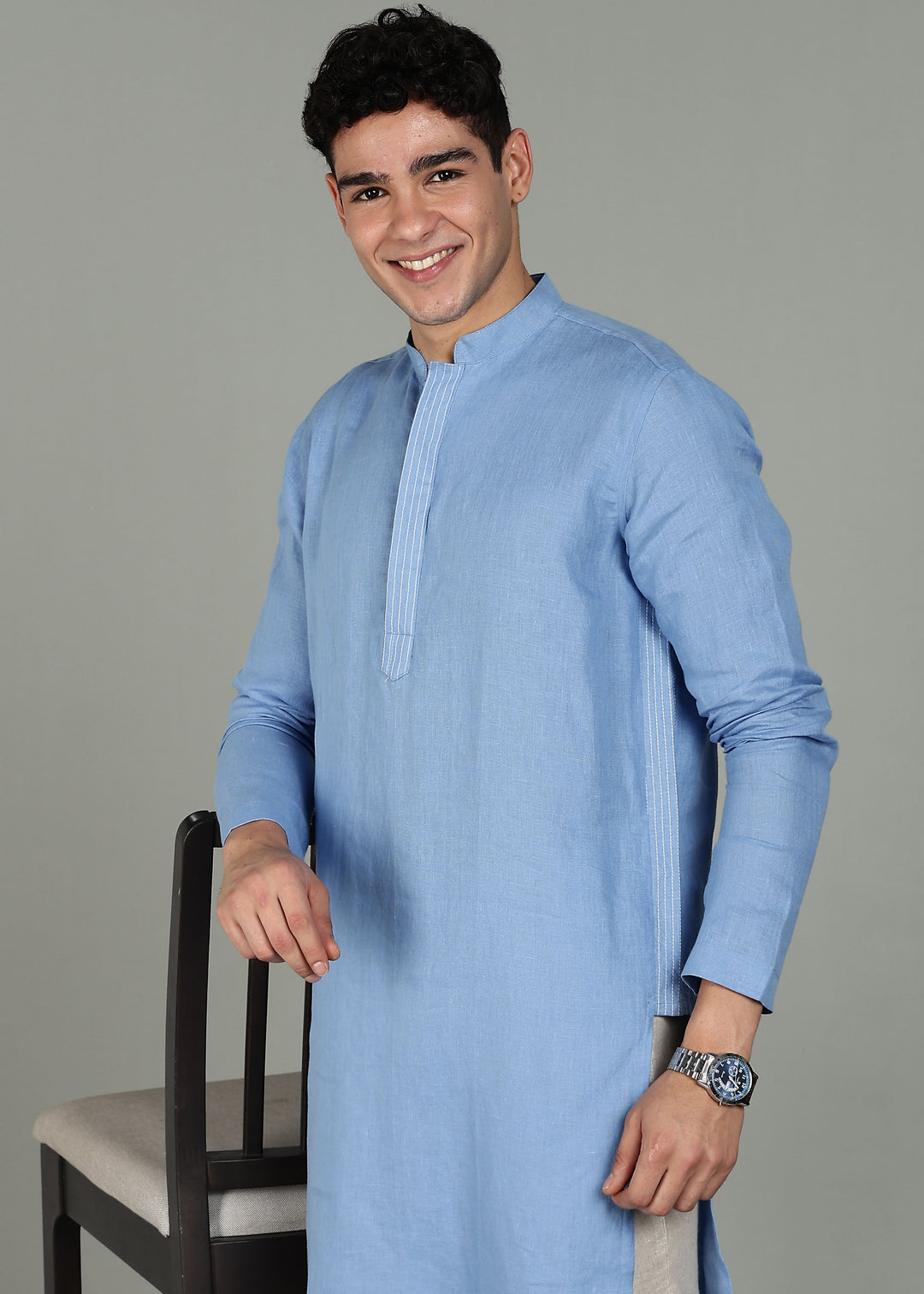 Man wearing a 100% pure linen olympic blue long kurta in 60 LEA with white detailing against a gray background