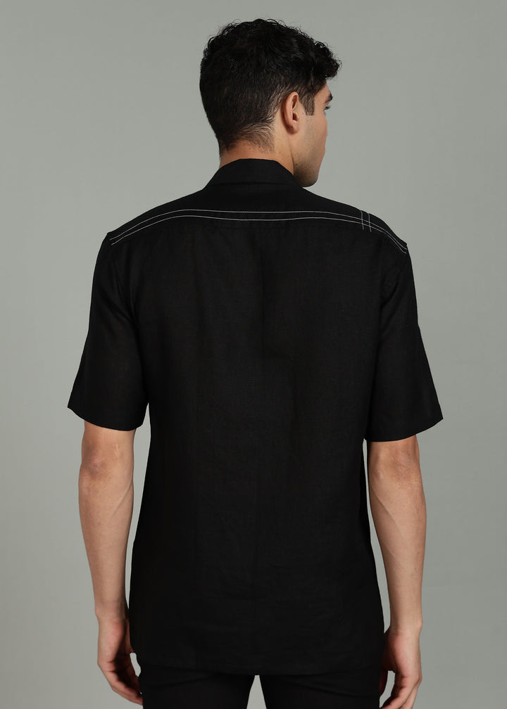 Man wearing a 100% pure linen black shirt in 60 LEA with elephant embroidery on a gray background