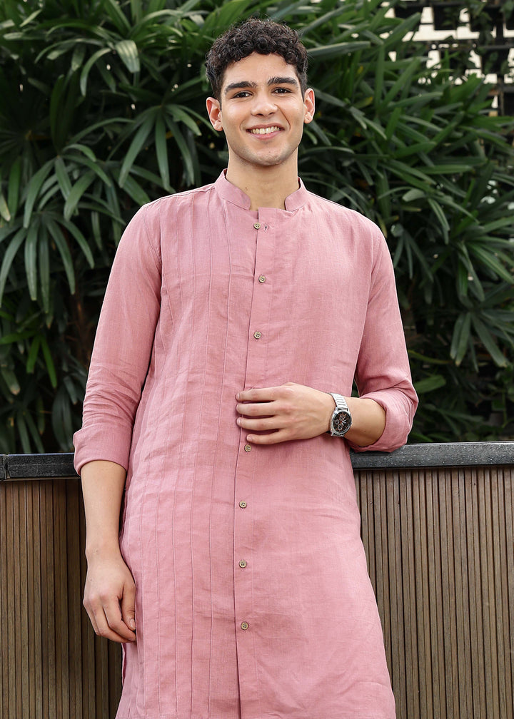 Man wearing a 100% Dusty pink yellow Kurta, in a Green outdoor Background.