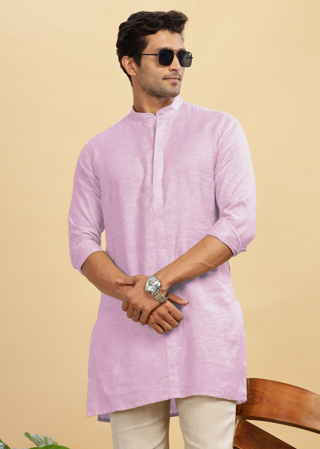 Man wearing a 100% pure linen hermosa pink kurta with beige pants on a beige background