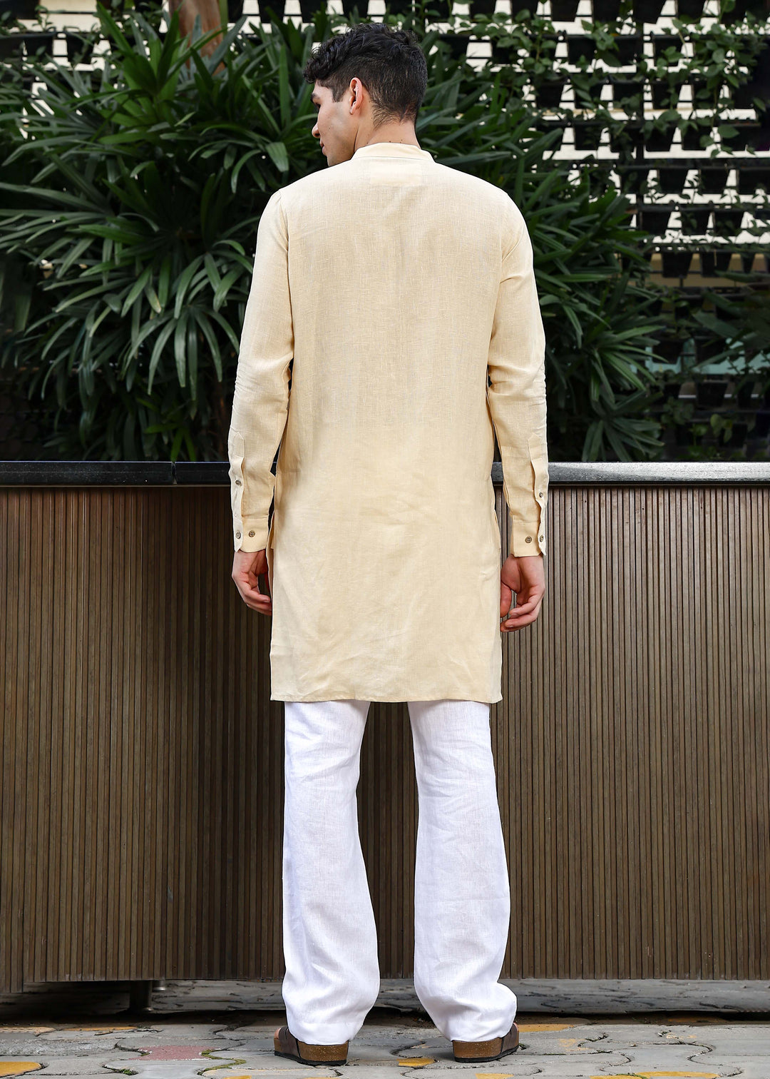 Man wearing a 100% pure light tea yellow Kurta, in a Green outdoor Background.