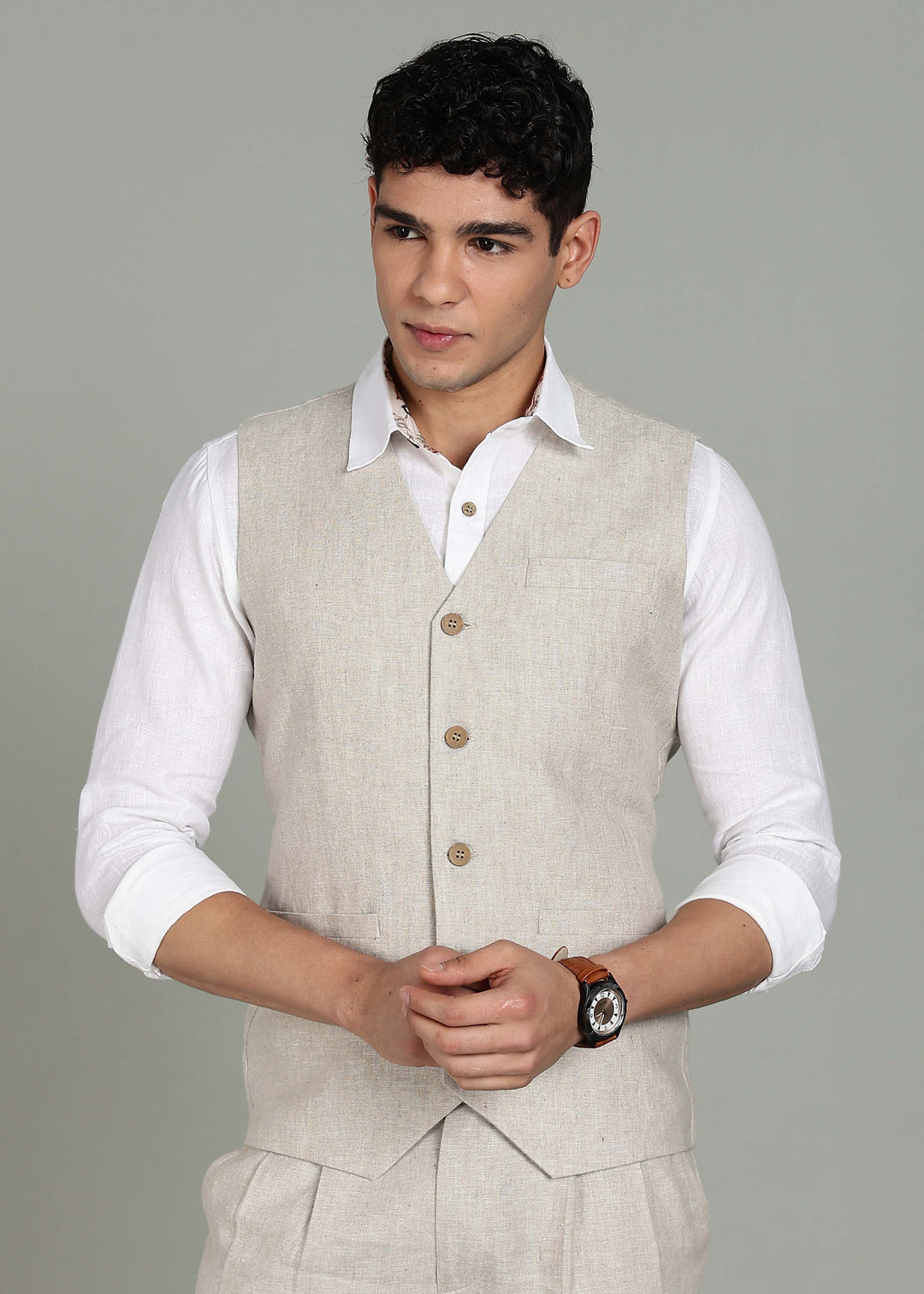 Man wearing a 100% pure linen ecru waistcoat in 25 LEA over a white shirt against a gray background