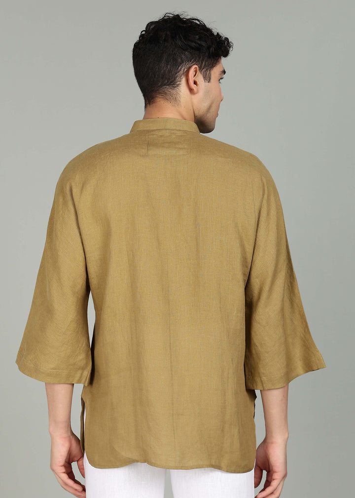 Man wearing a 100% pure linen golden olive green short kurta in 60 LEA with white pants against a gray background