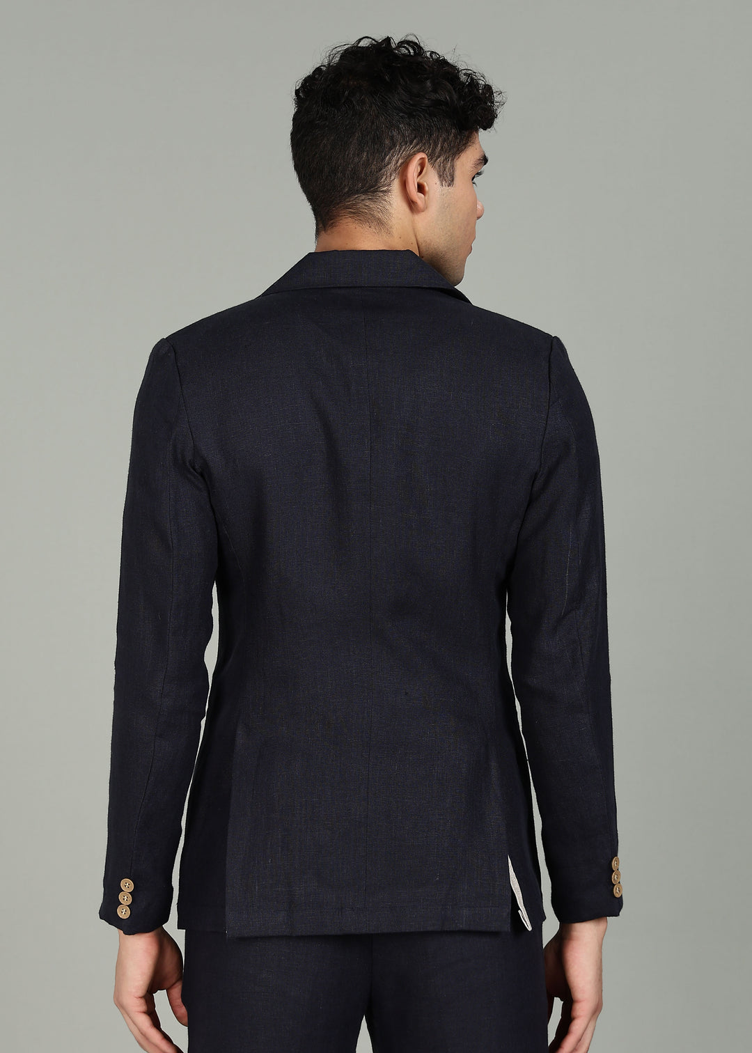 Man wearing a 100% pure linen regal blue jacket in 25 LEA over a white shirt on a gray background