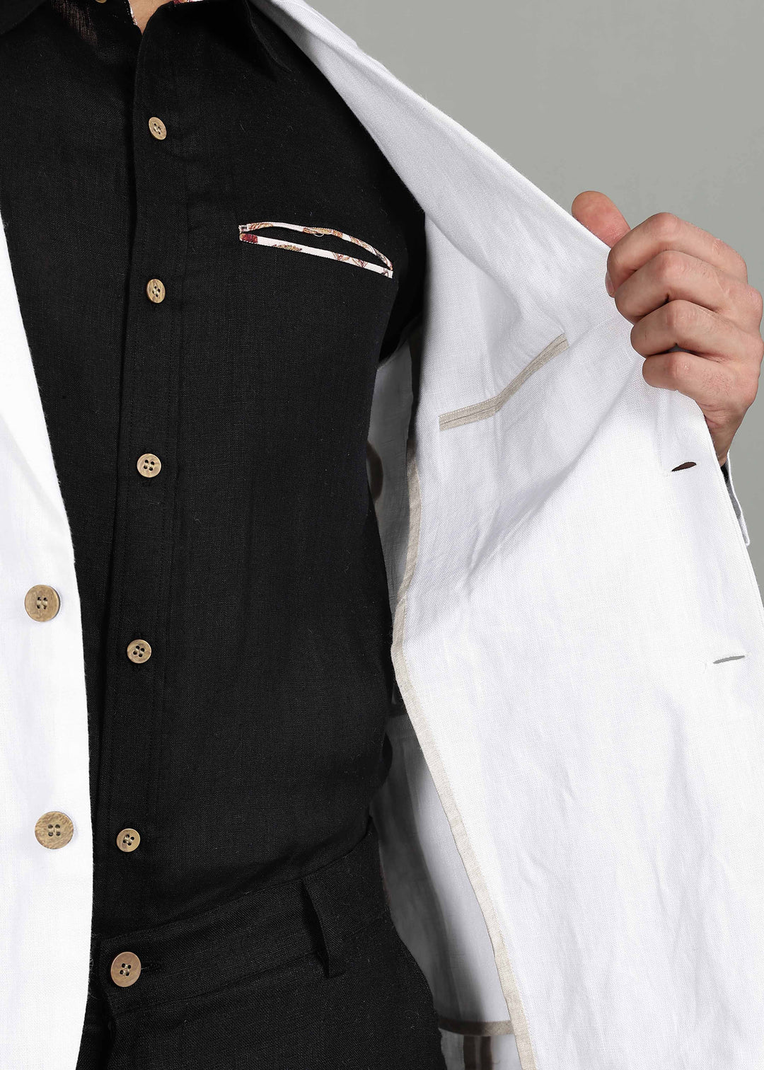 Man wearing a 100% pure linen white Jacket in 25 LEA over a black shirt on a gray background