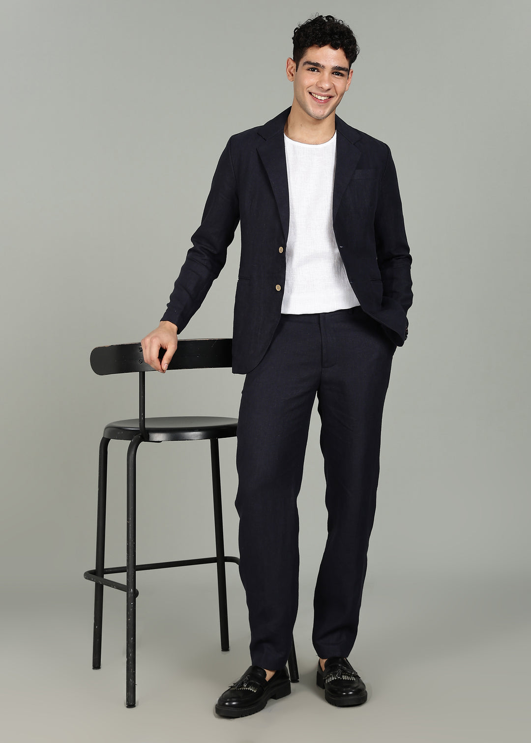 Man wearing a 100% pure linen regal blue jacket in 25 LEA over a white shirt on a gray background