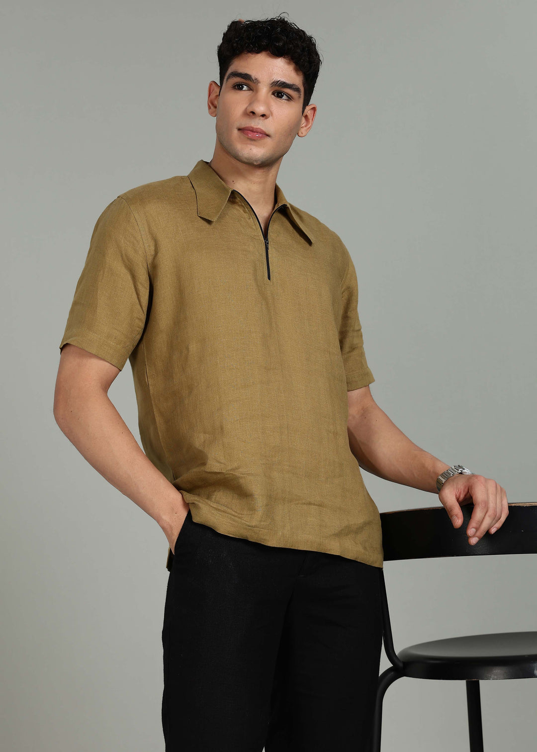 Man wearing 100% 60 LEA Linen Golden Olive Green T - Shirt in an indoor grey background.