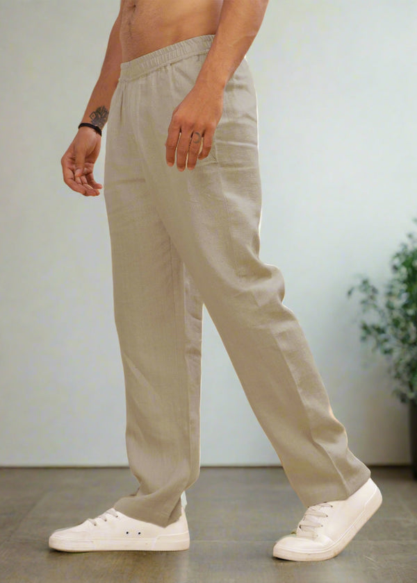 A pair of ecru linen casual elastic pants, displayed on a model wearing white sneakers.