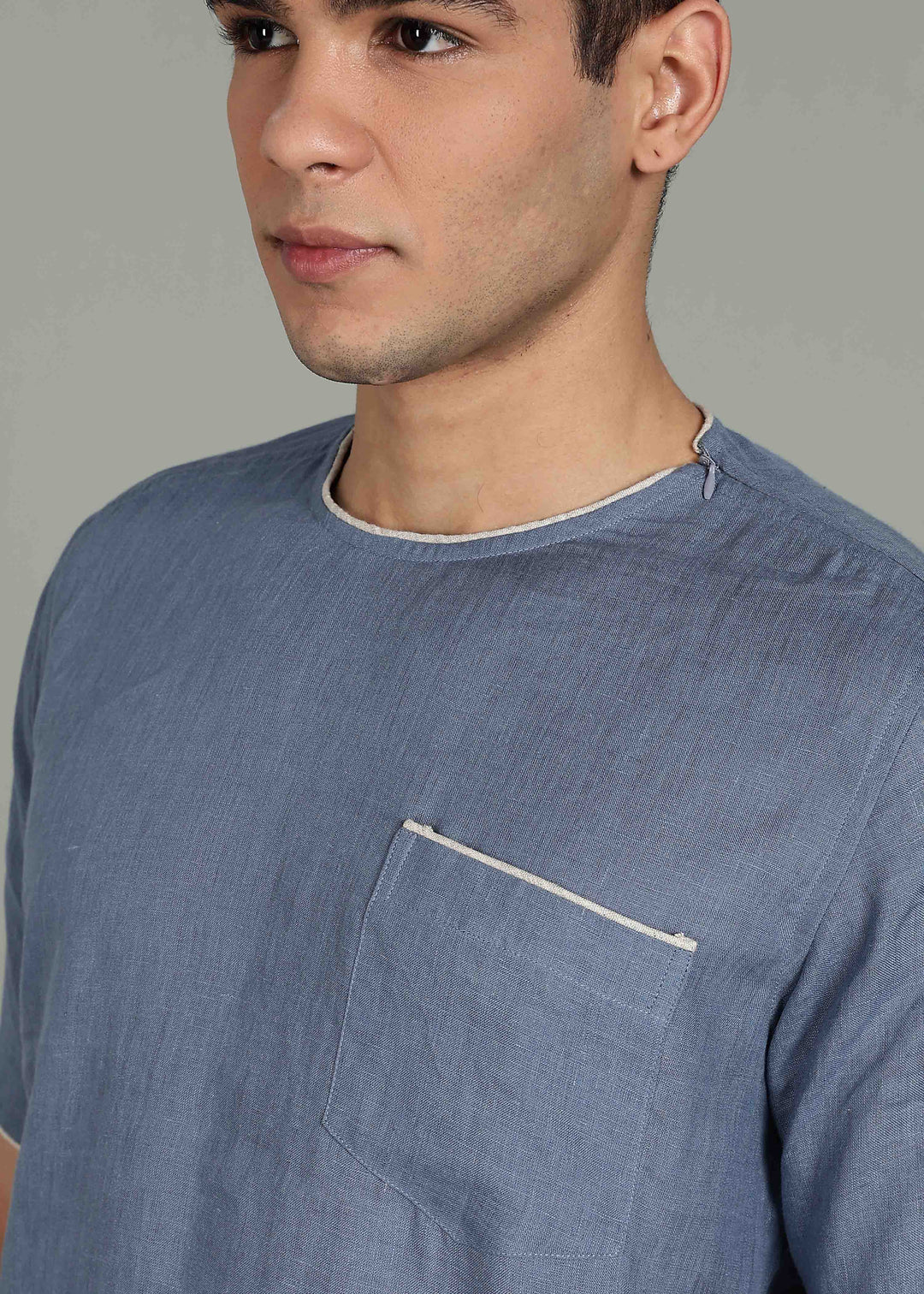 Man wearing 100% Linen Blue Grey T - Shirt in an indoor grey background