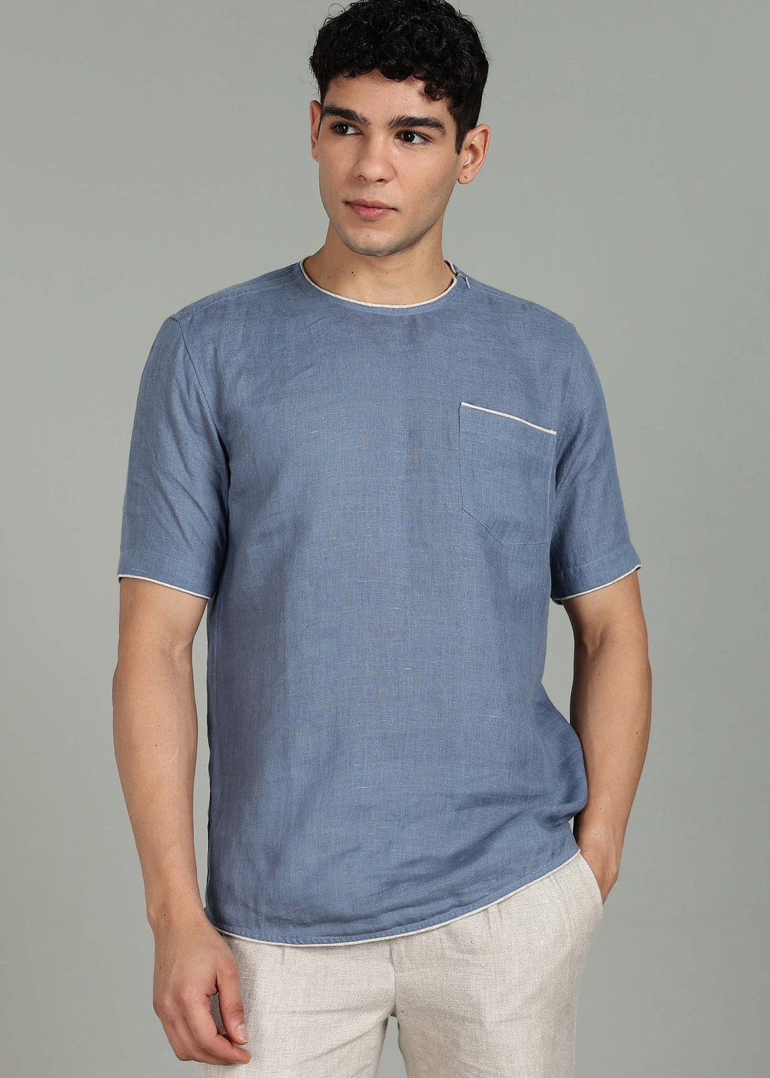 Man wearing 100% Linen Blue Grey T - Shirt in an indoor grey background