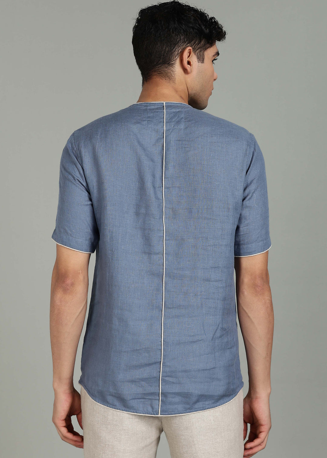 Man wearing 100% Linen Blue Grey T - Shirt in an indoor grey background