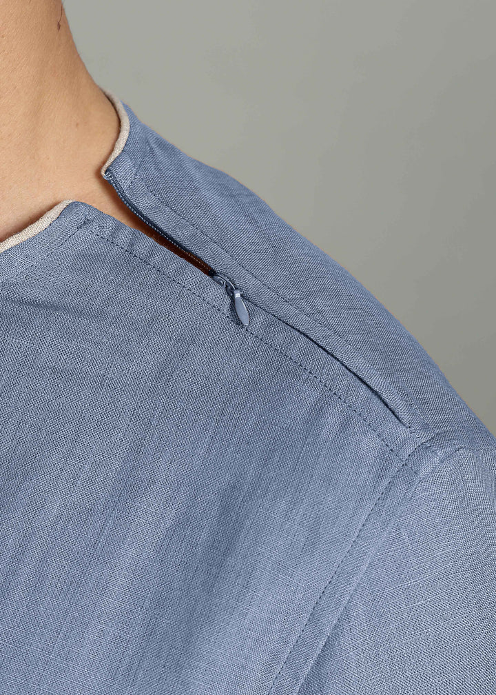Man wearing 100% Linen Blue Grey T - Shirt in an indoor grey background