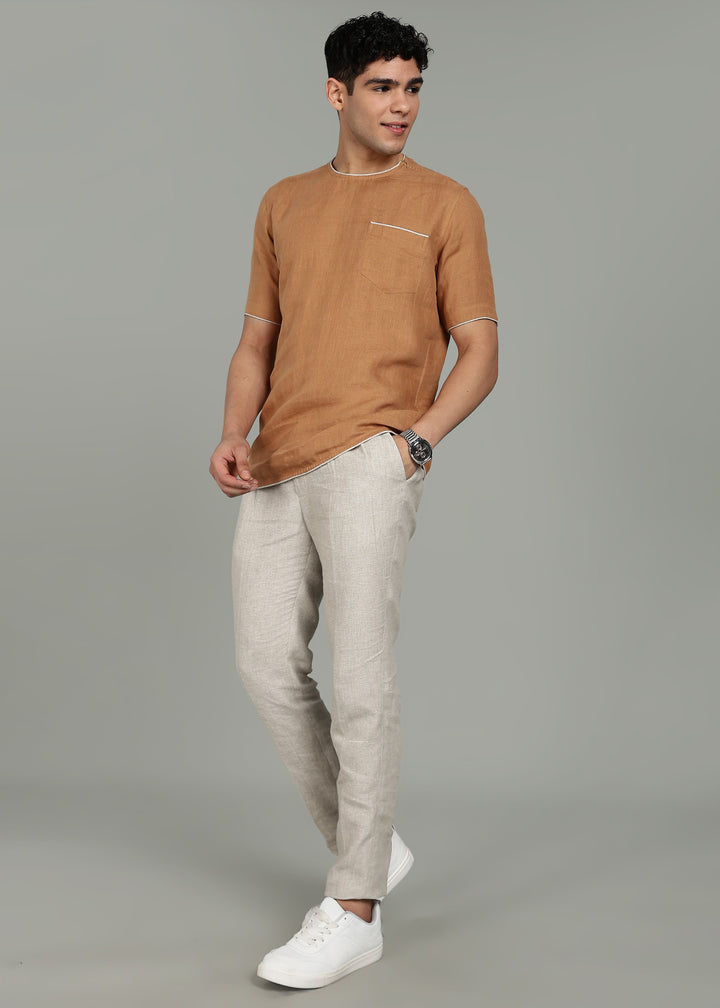 Man wearing 100% Linen Mustard Brown T - Shirt in an indoor grey background