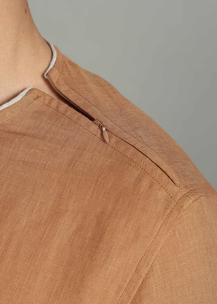 Man wearing 100% Linen Mustard Brown T - Shirt in an indoor grey background