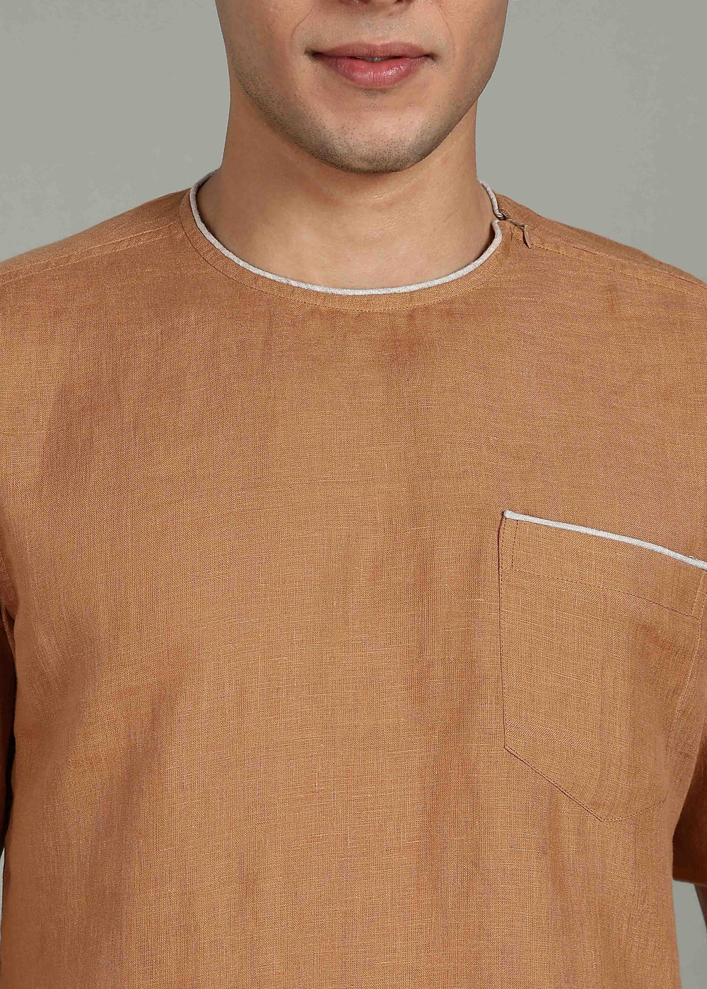 Man wearing 100% Linen Mustard Brown T - Shirt in an indoor grey background