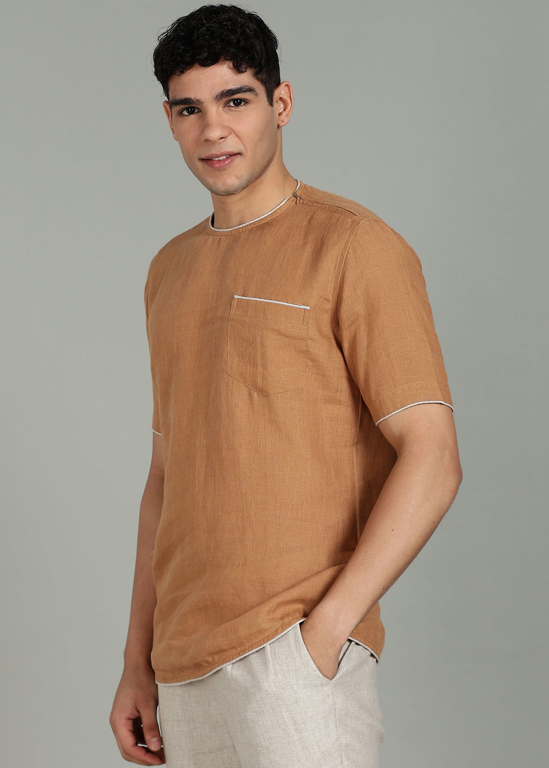 Man wearing 100% Linen Mustard Brown T - Shirt in an indoor grey background