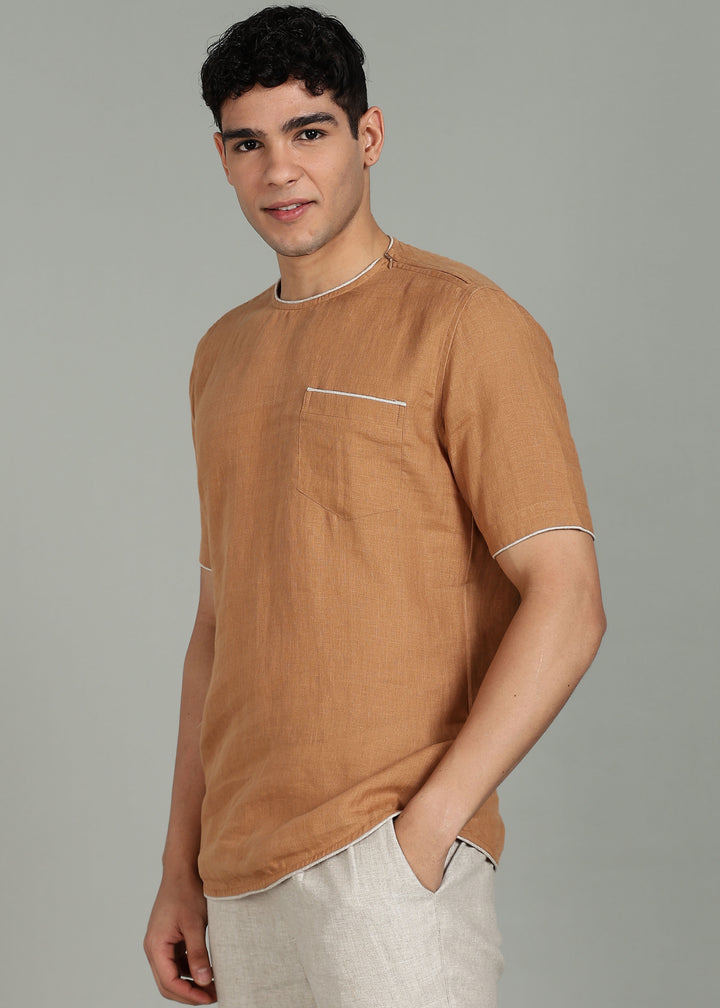 Man wearing 100% Linen Mustard Brown T - Shirt in an indoor grey background