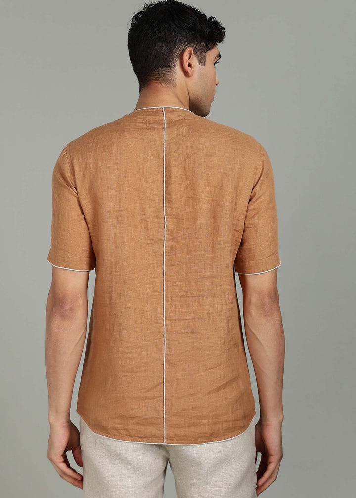 Man wearing 100% Linen Mustard Brown T - Shirt in an indoor grey background