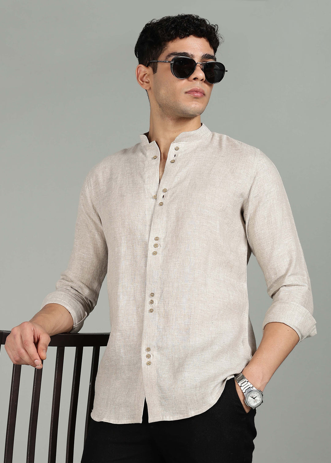 Man wearing a 100% pure linen ecru full sleeve shirt in 60 LEA and sunglasses against a gray background