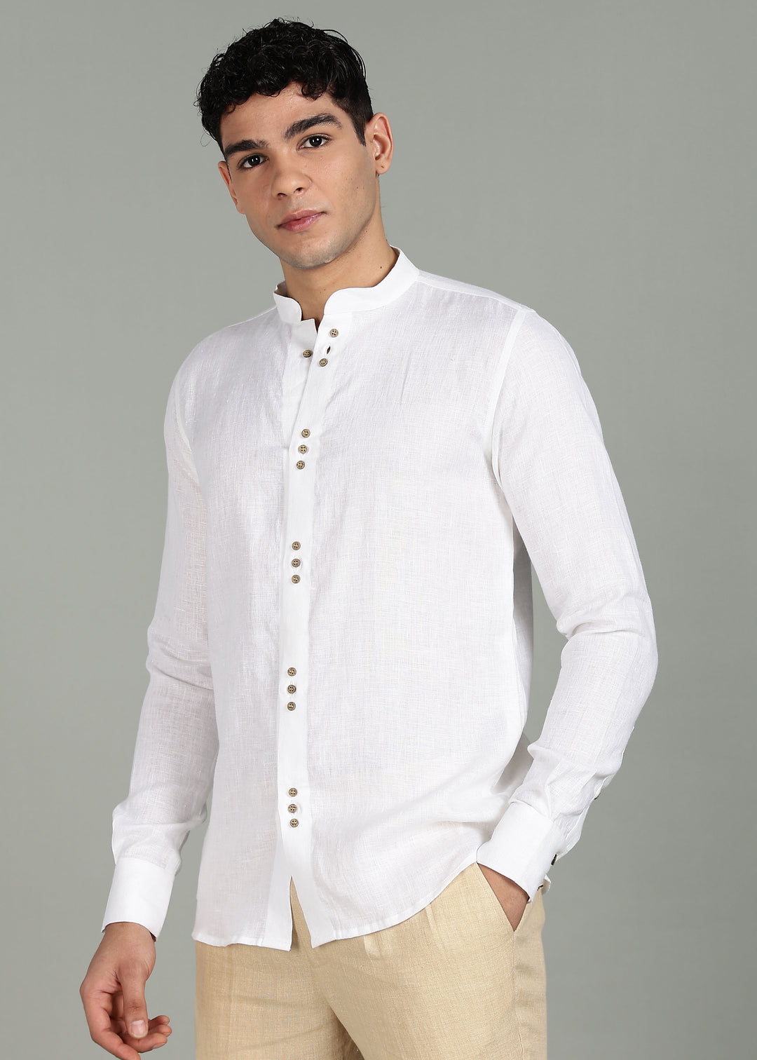Man wearing a 100% pure linen white full sleeve shirt in 44 LEA with beige pants against a gray background