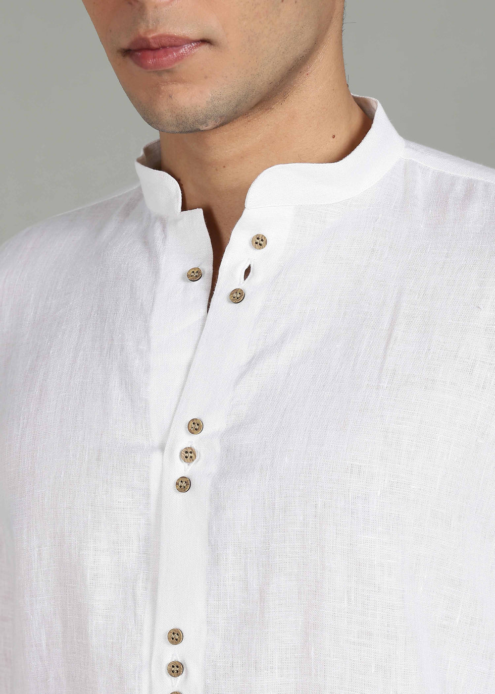 Close-up of a 100% pure linen white full sleeve shirt in 44 LEA with wooden buttons on a neutral background
