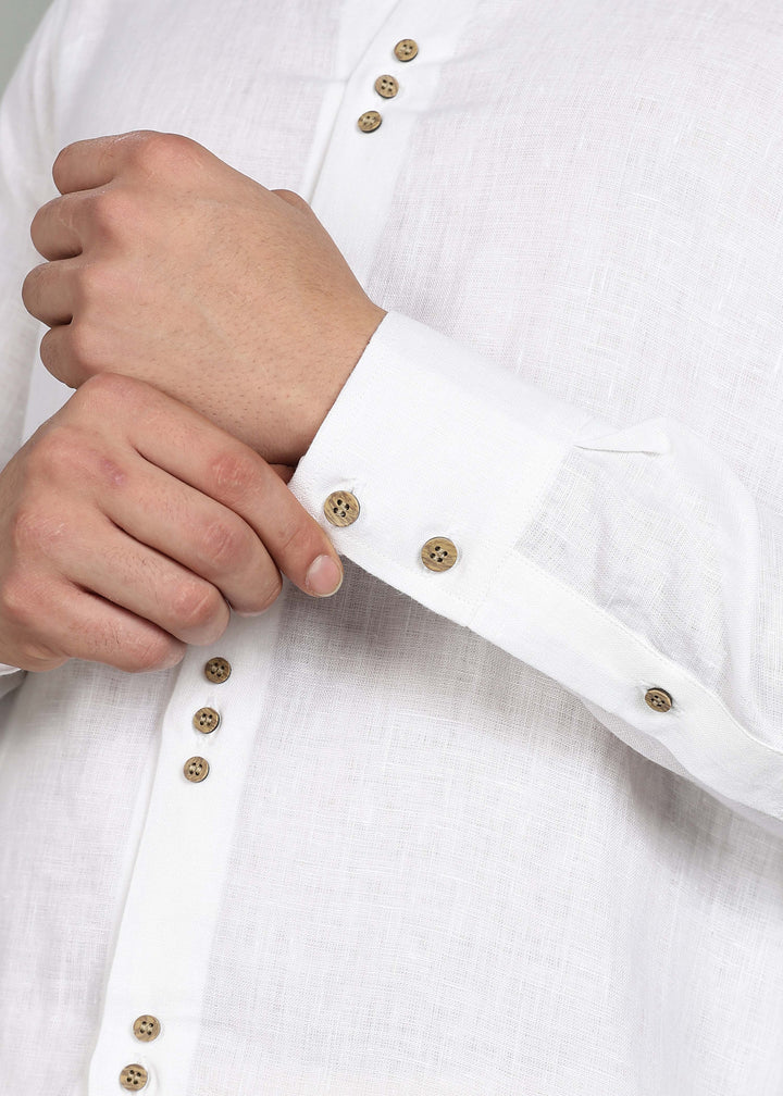 Close-up of a 100% pure linen white full sleeve shirt in 44 LEA with wooden buttons being adjusted by a hand.