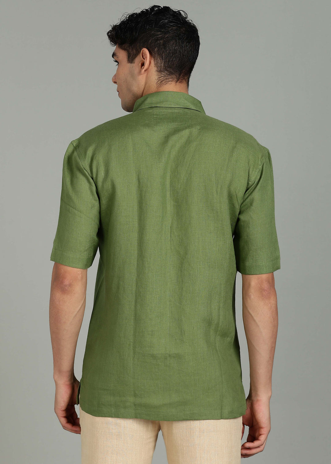 Man wearing 100% 60 LEA Cossack Green Half sleeve Shirt in an indoor grey background.