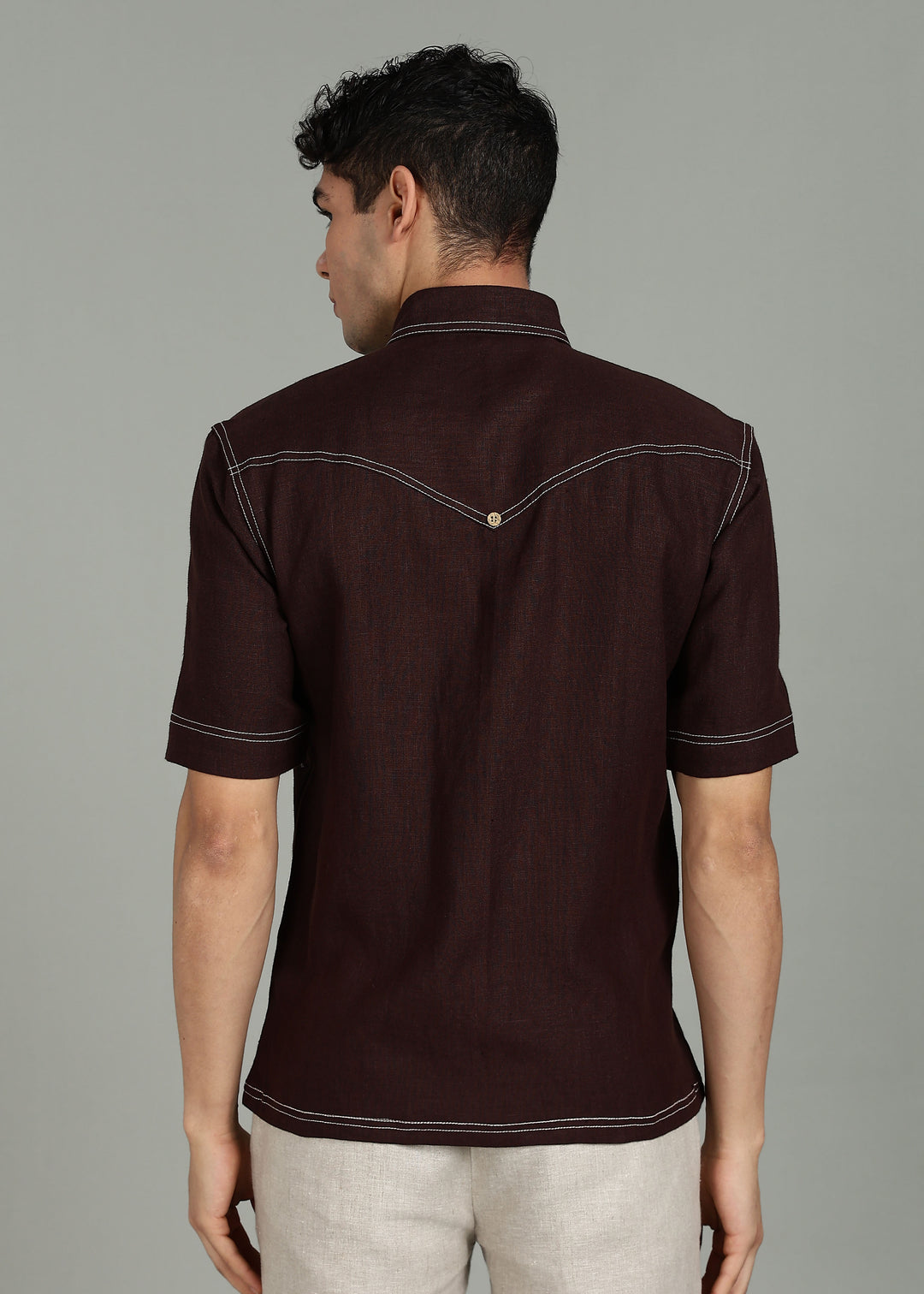 Man wearing 100% 25 LEA Cocoa Brown Half sleeve Shirt in an indoor grey background.