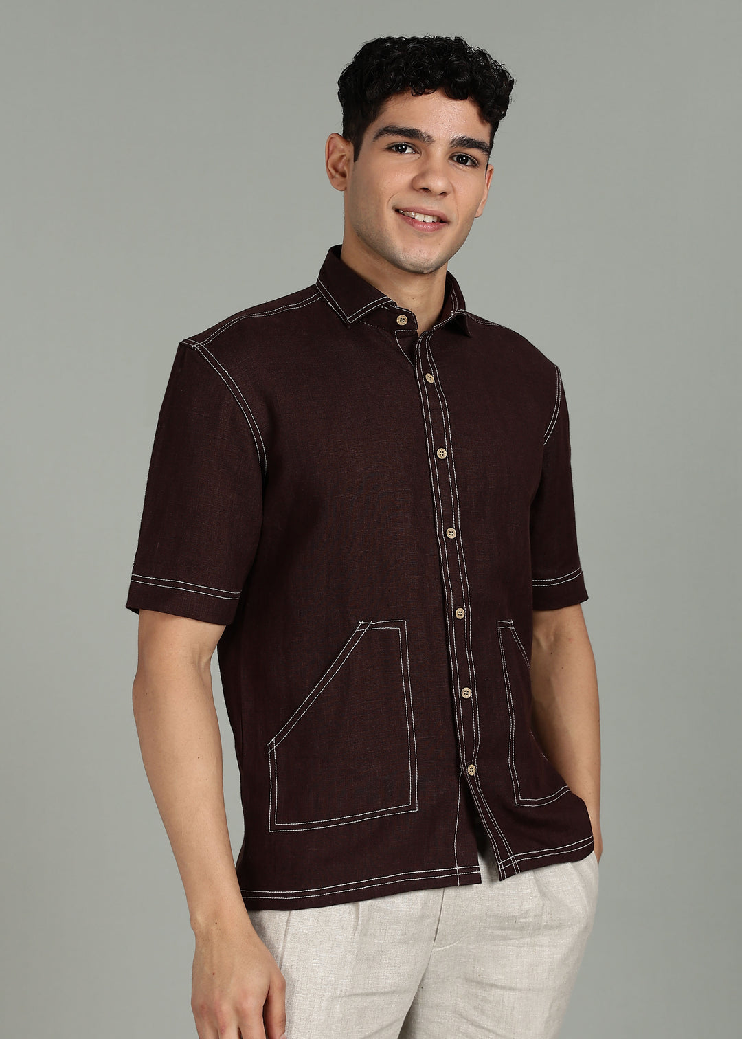 Man wearing 100% 25 LEA Cocoa Brown Half sleeve Shirt in an indoor grey background.