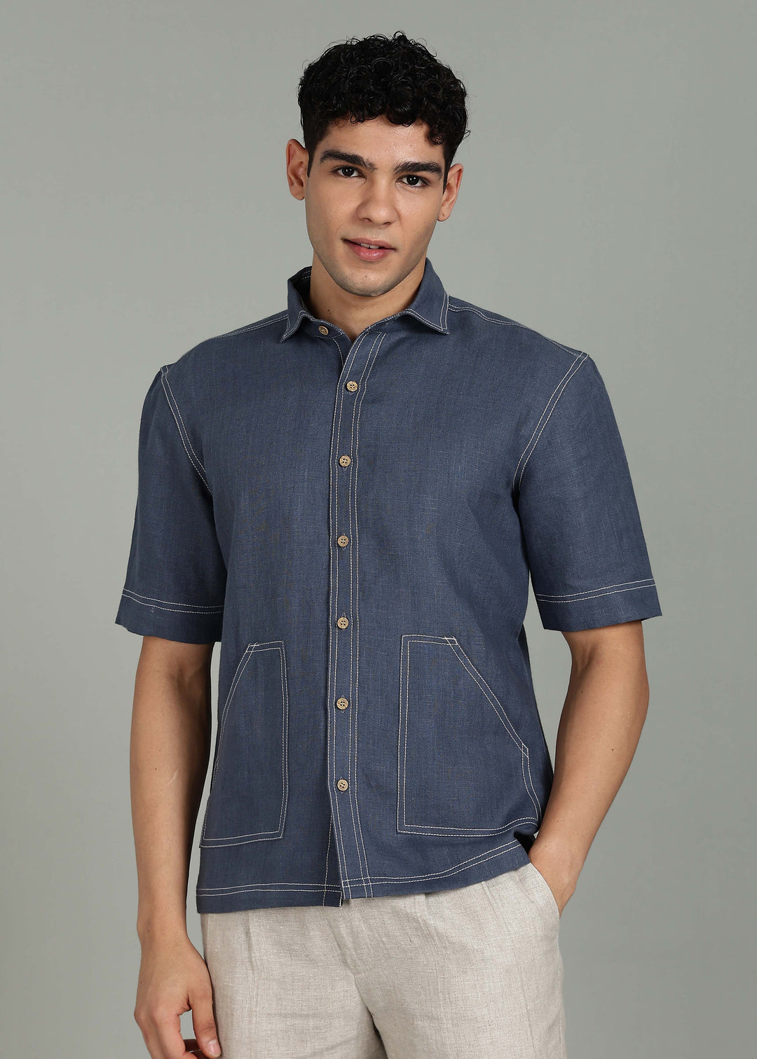 Man wearing 100% 25 LEA Dark Blue Grey Half sleeve Shirt in an indoor grey background.