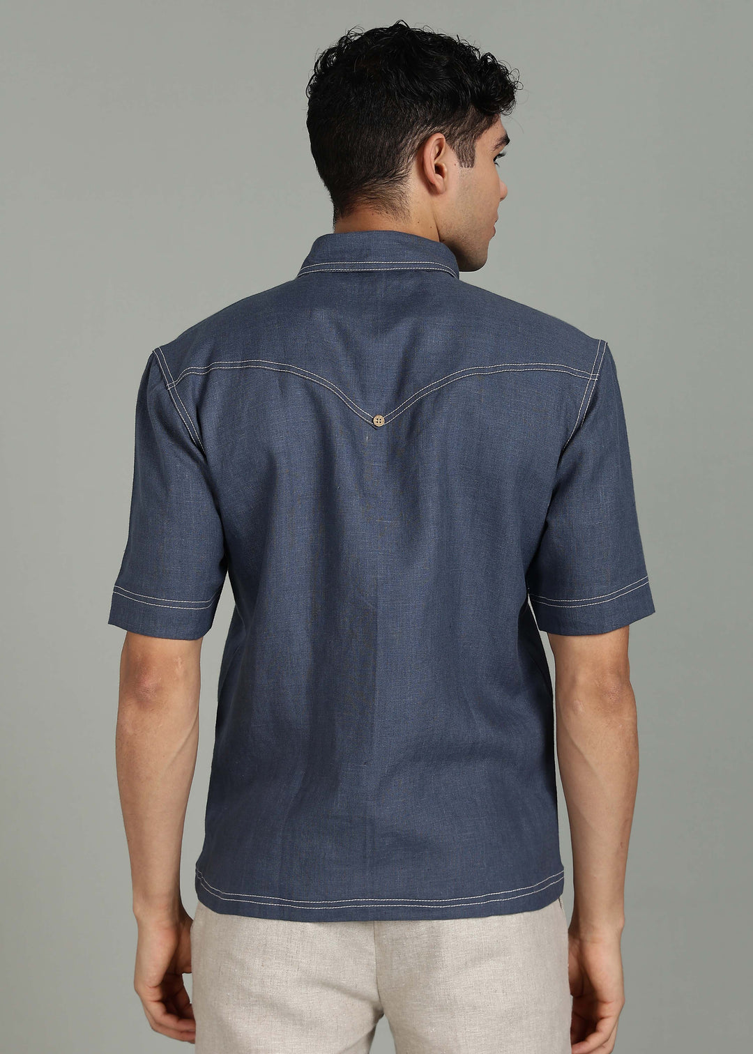 Man wearing 100% 25 LEA Dark Blue Grey Half sleeve Shirt in an indoor grey background.