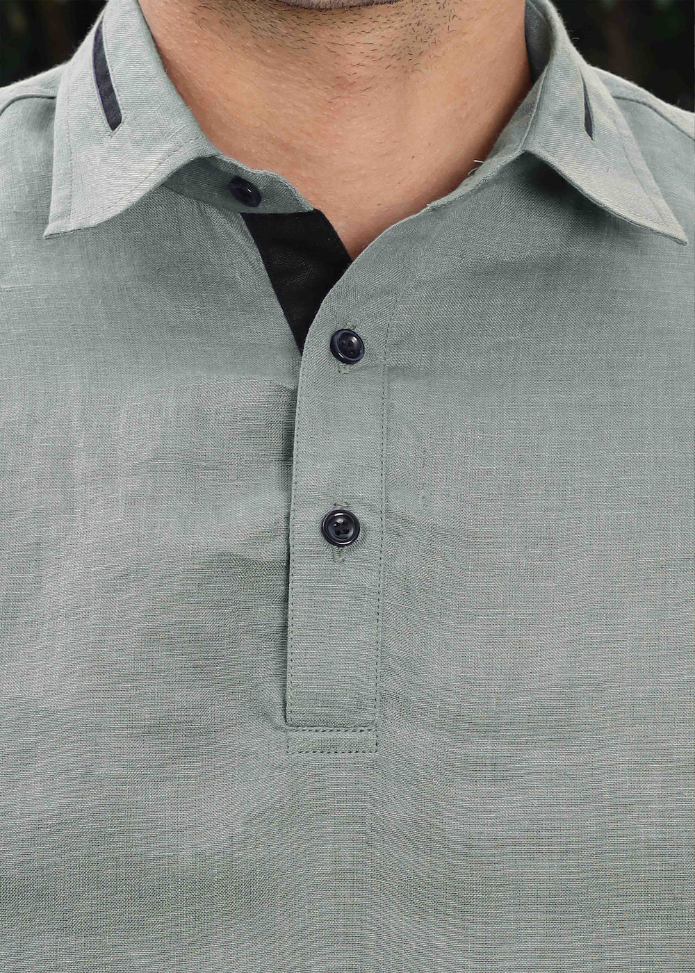 Close-up of a 100% pure linen gray t-shirt with black buttons on a blurred background