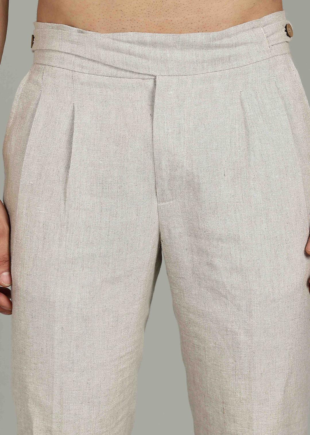 Man wearing 100% 25 LEA Ecru formal pants in an indoor grey background.