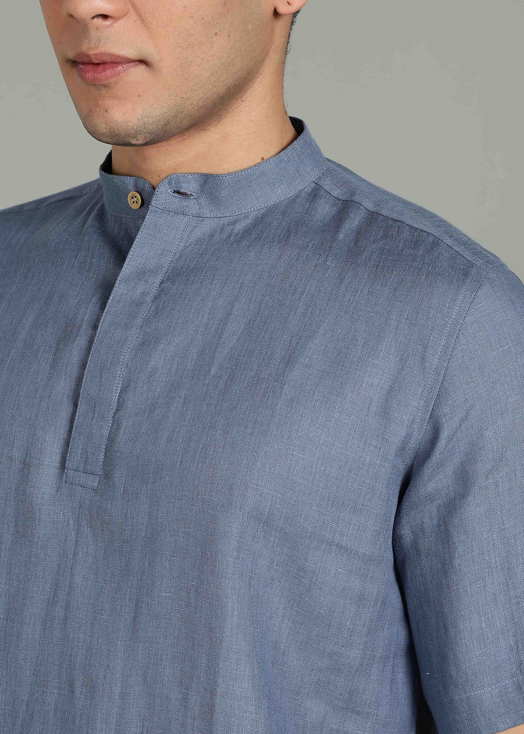 Man wearing 100% 60 LEA Blue grey Half sleeve Shirt in an indoor grey background.