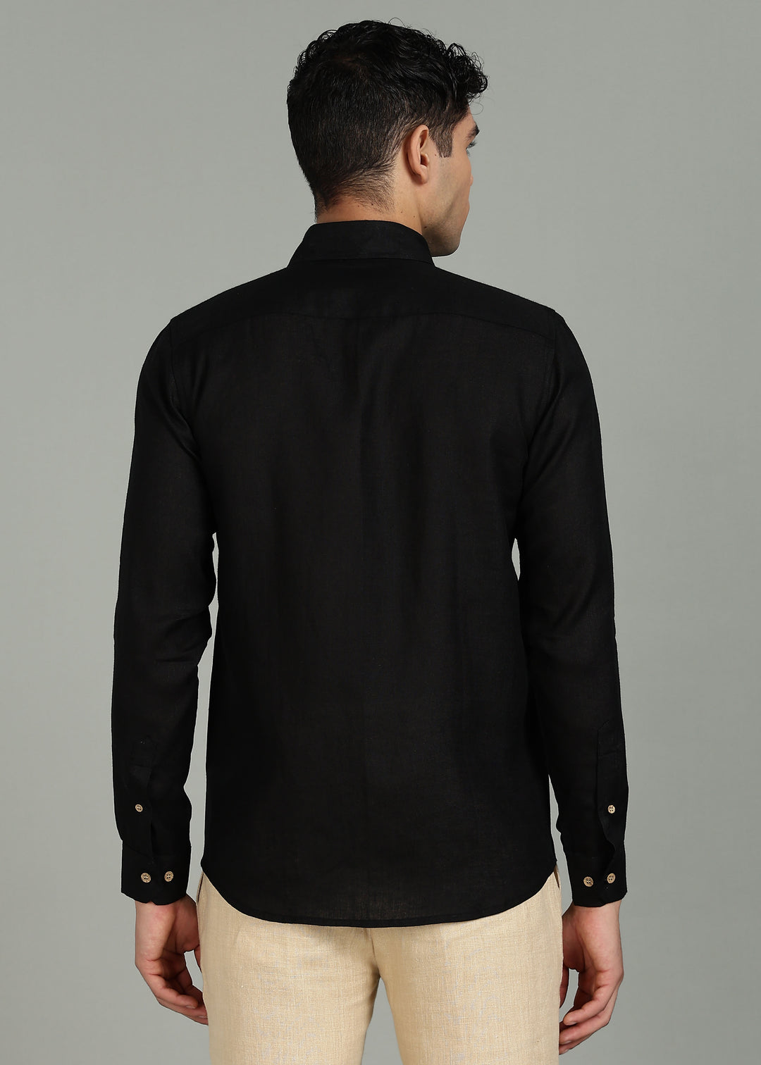 Man wearing a 100% pure linen black shirt with a subtle pattern in 60 LEA on a gray background