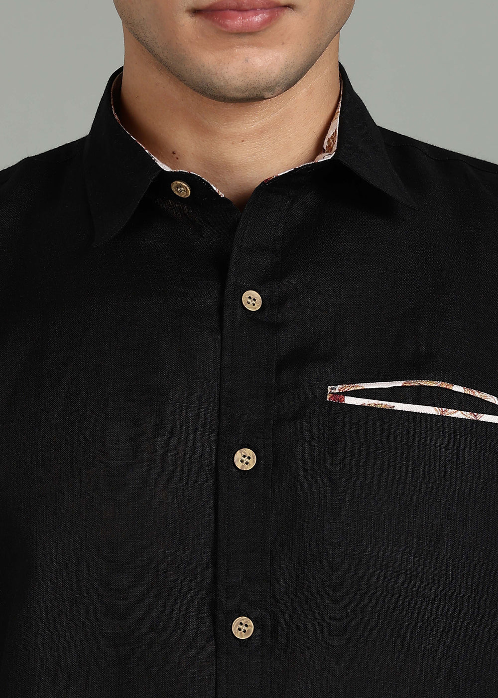 Man wearing a 100% pure linen black shirt with a subtle pattern in 60 LEA on a gray background