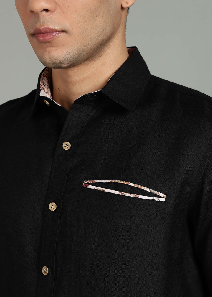 Man wearing a 100% pure linen black shirt with a subtle pattern in 60 LEA on a gray background
